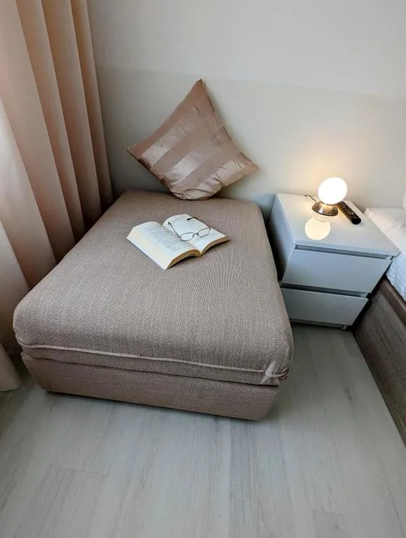 Uma cama individual com um livro aberto sobre a colcha