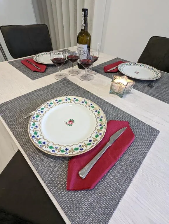 A mesa posta para o jantar, pratos decorados e copos de vinho