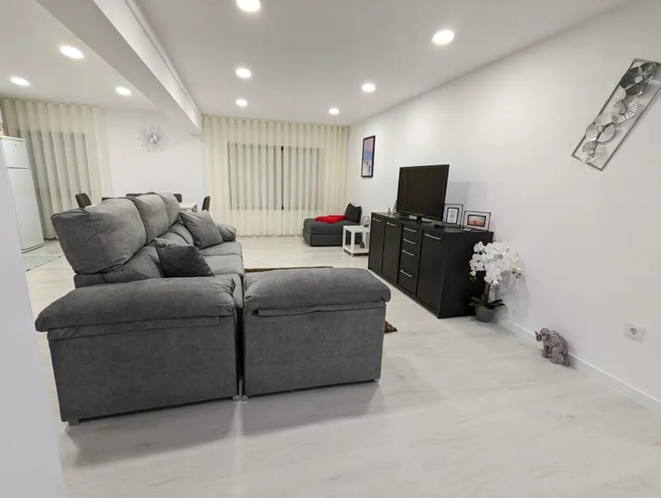 Sala de estar com sofá amplo e televisão